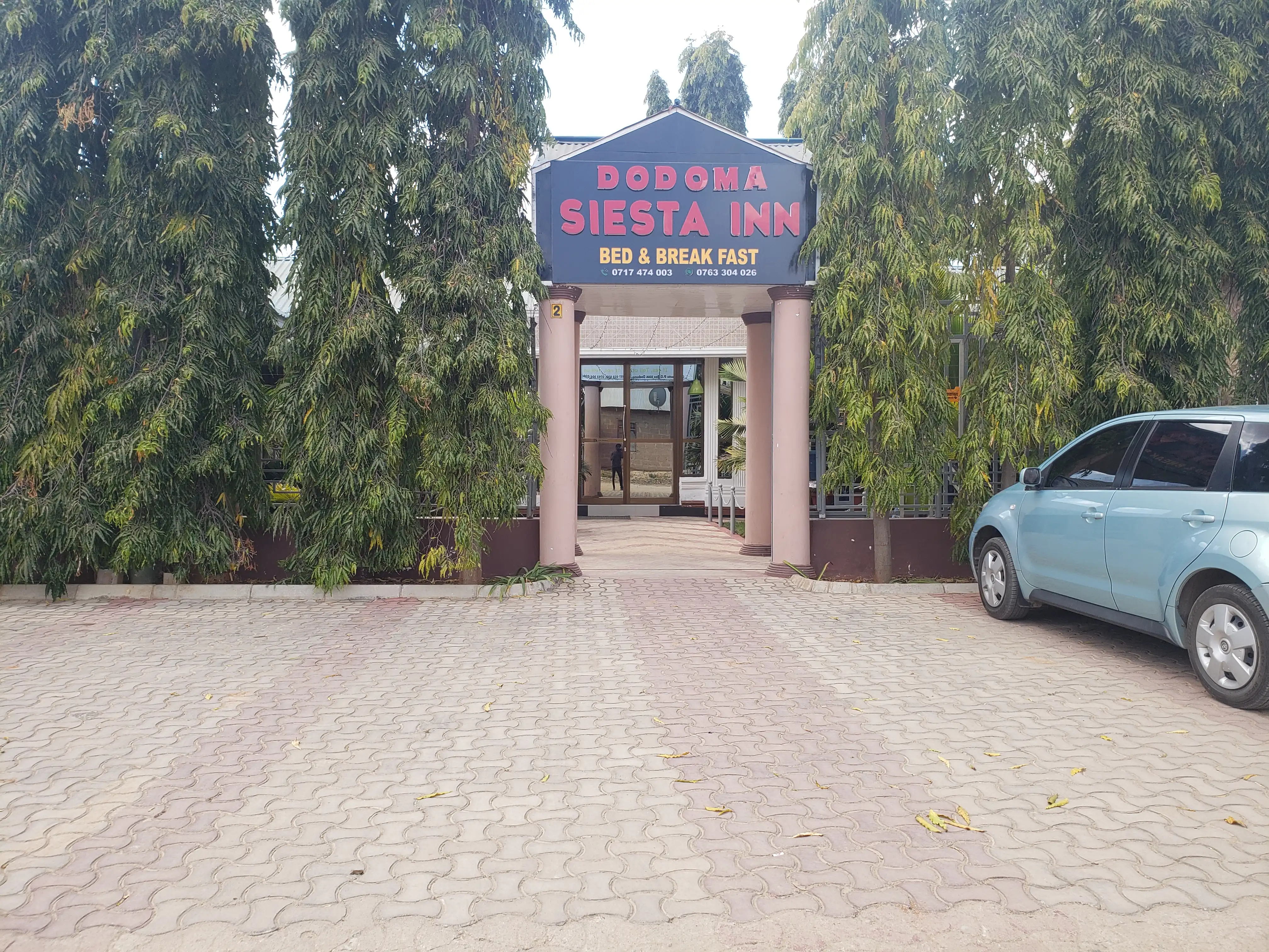 The paved forecourt and signage of the inn